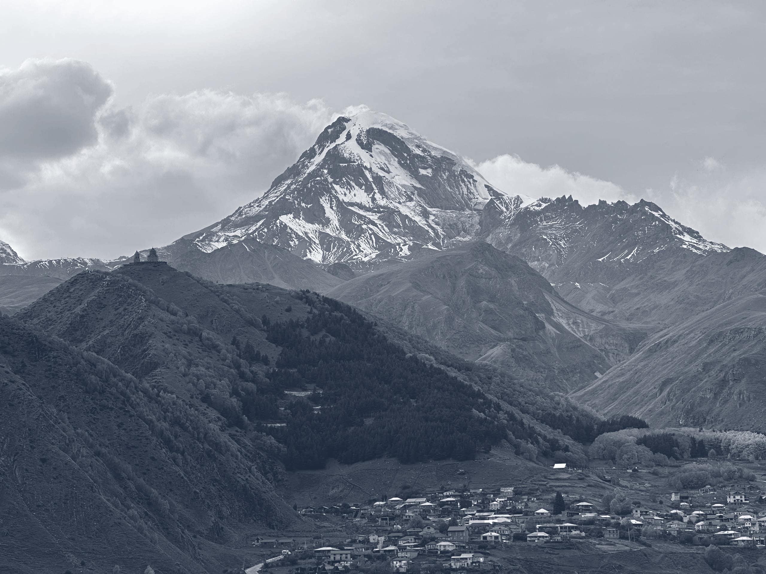 Mount Kazbek and Gergeti Trinity Church above Stepantsminda, Georgia, in a slate-blue duotone